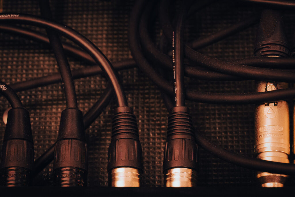 Close up of microphone cables plugging into a mixing board. 