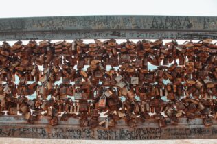 Old rusty locks hanging on a cement wall in city