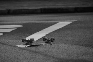 Grayscale photo of an upside down skateboard