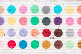 Colourful circles on a brick wall.