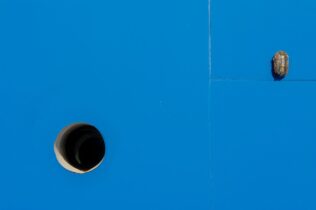 Blue background interrupted by a lamp and a pipe opening