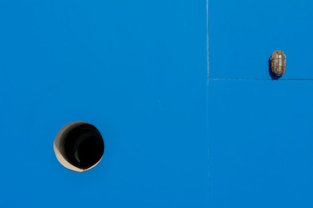Blue background interrupted by a lamp and a pipe opening